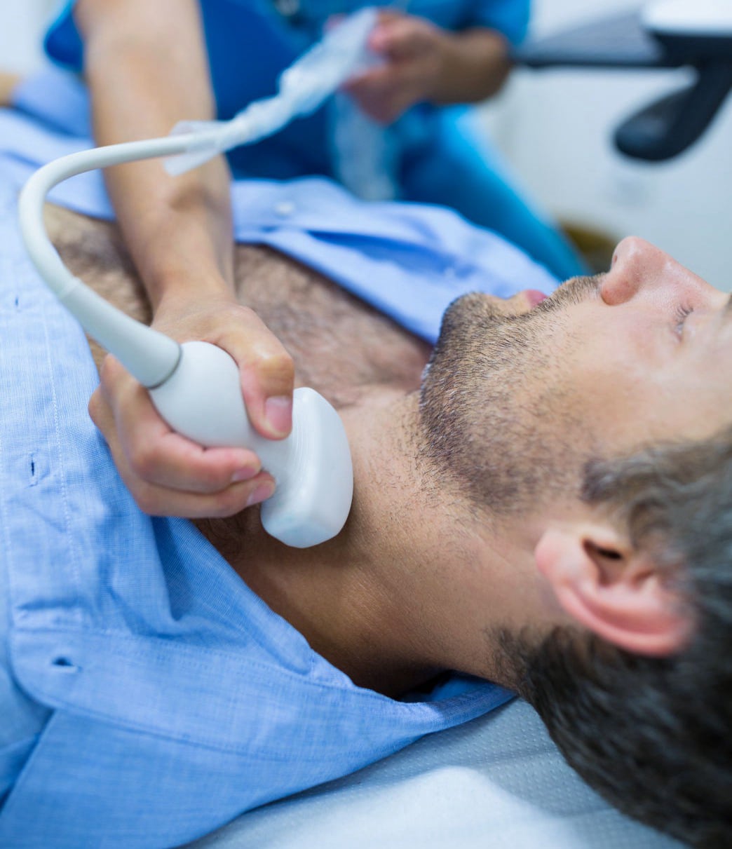 Médico realizando Ultrassonografia da tireoide